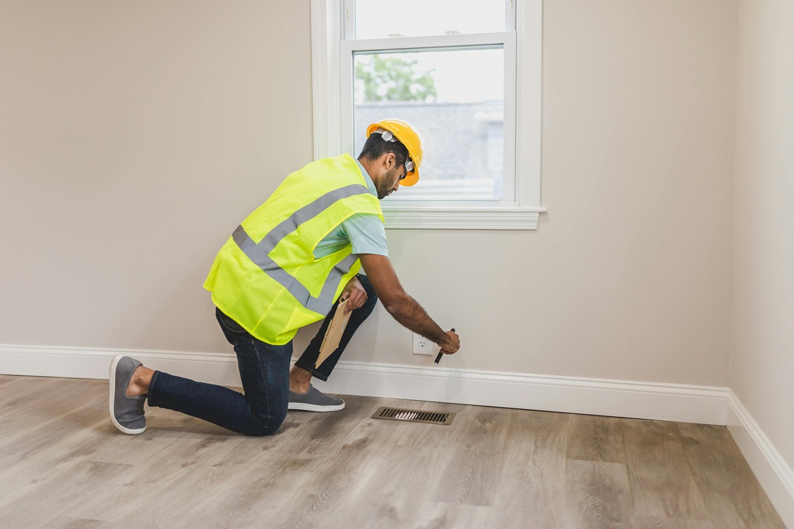 Technician taking moisture metre readings from a wall or subfloor