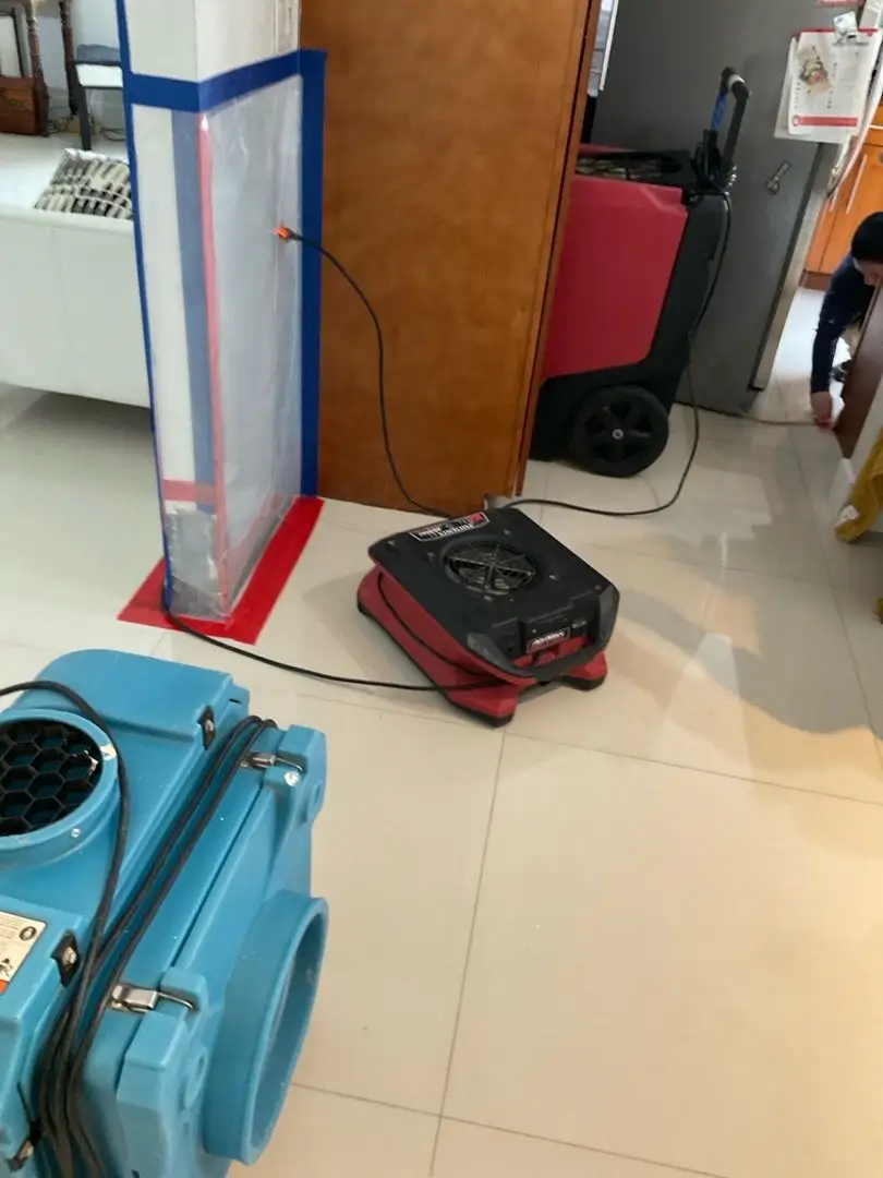 Professional drying equipment including dehumidifiers and air movers set up in a residential property